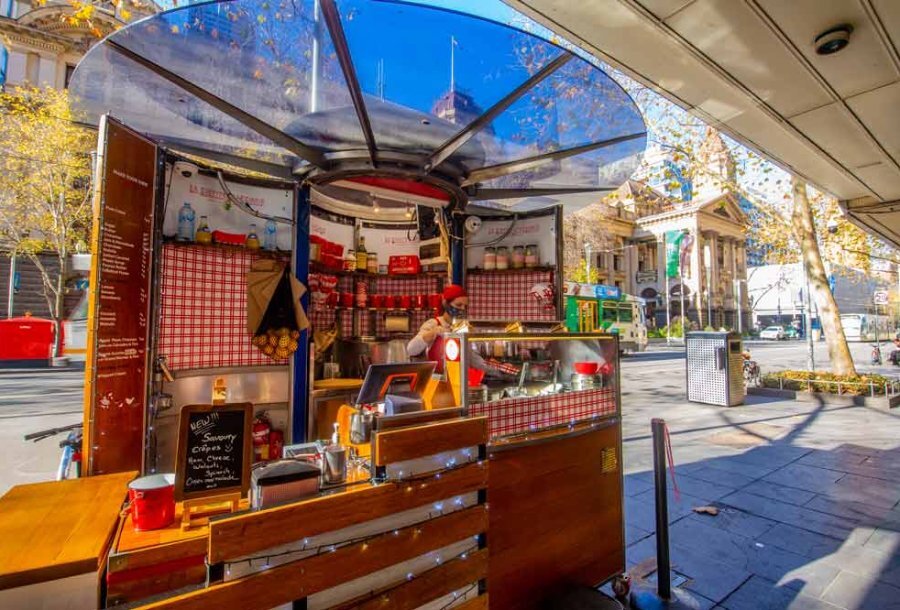 An outdoor kiosk serving french crepes.
