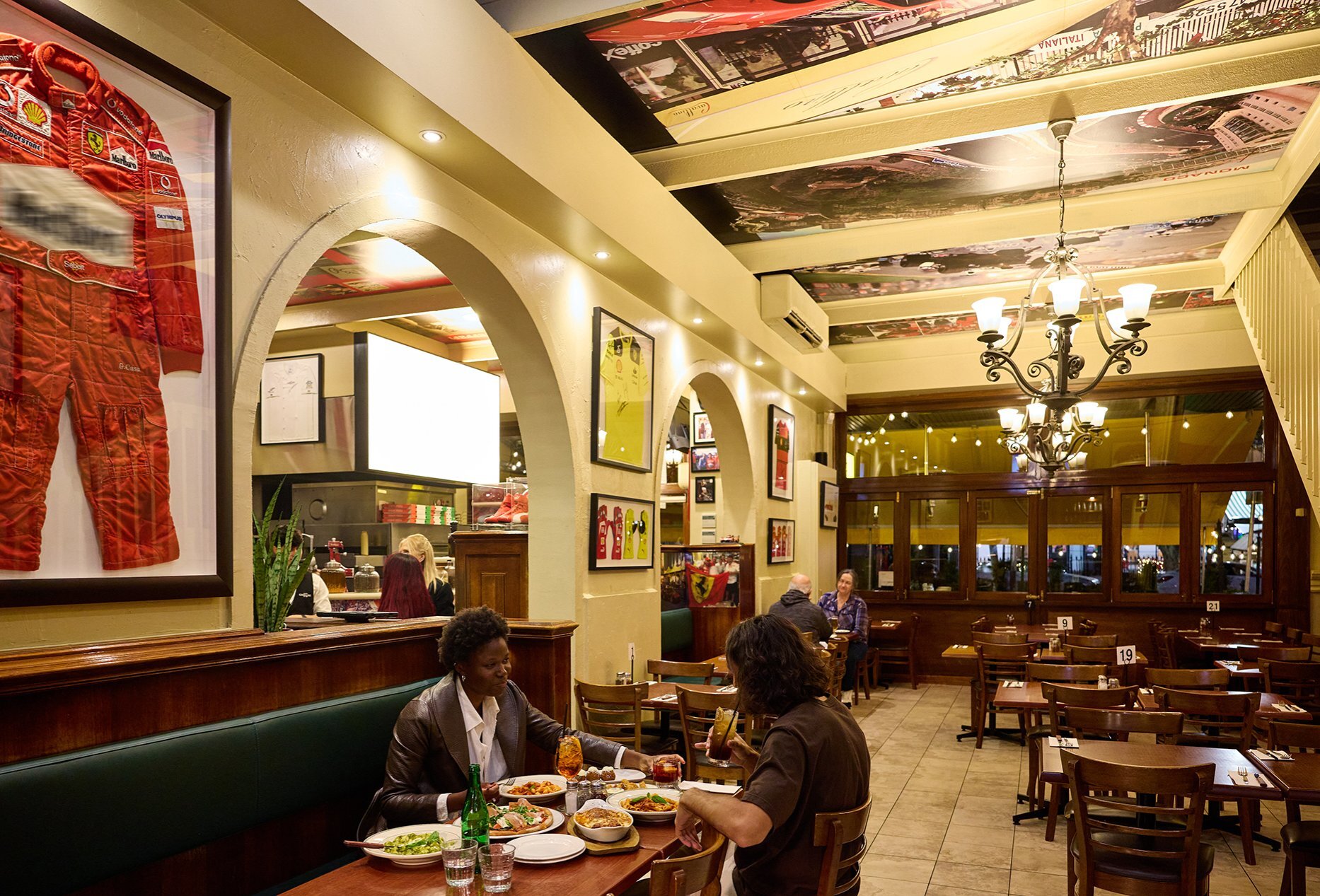 A couple dining in an Italian restaurant with Ferrari merch on the walls.