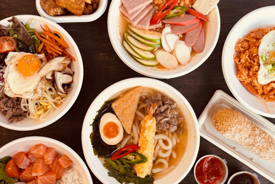 Overhead view looking down at a table of dishes of Korean food.