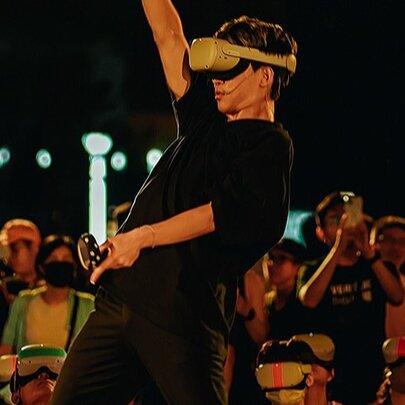 A person wearing a VR headset in front of a group of onlookers. 