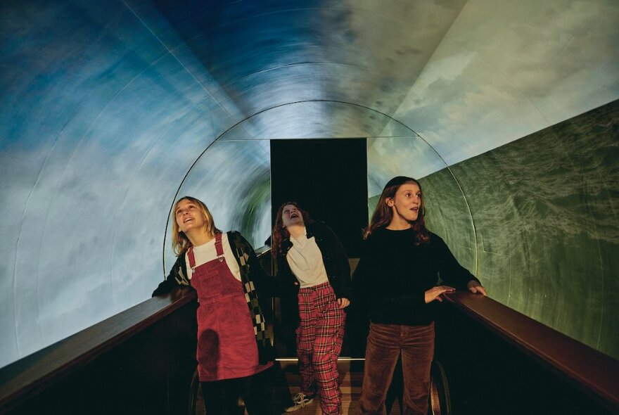 Three kids walking through a covered walkway.