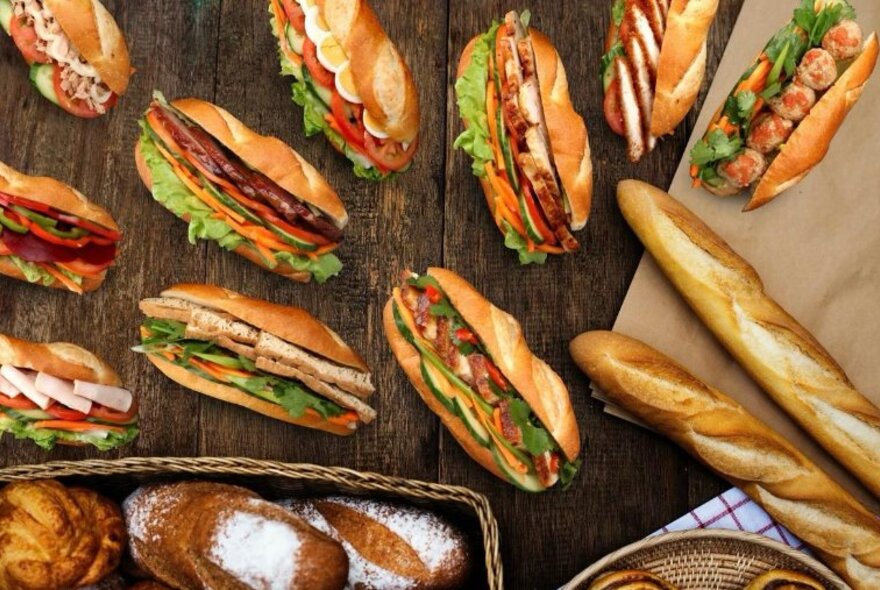 Overhead view of filled baguettes, breadsticks and loaves of bread.