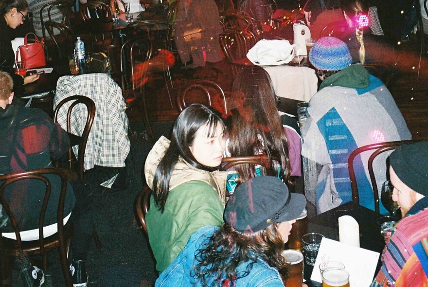 People seated at tables socialising at a club.