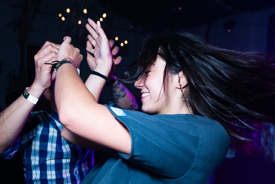 Male and female couple Latin dancing hand in hand.