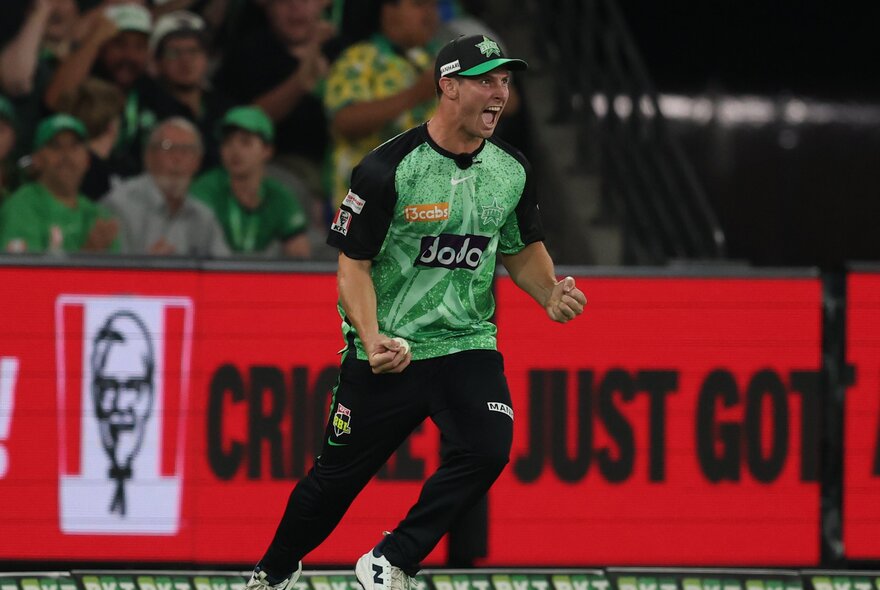 Melbourne Stars BBL plater happy after getting someone out, a KFC sign in the background. 
