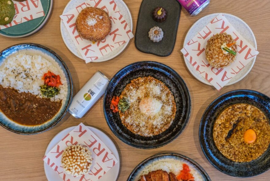 Bird's eye view shot of various plates of curry rice and sweets.