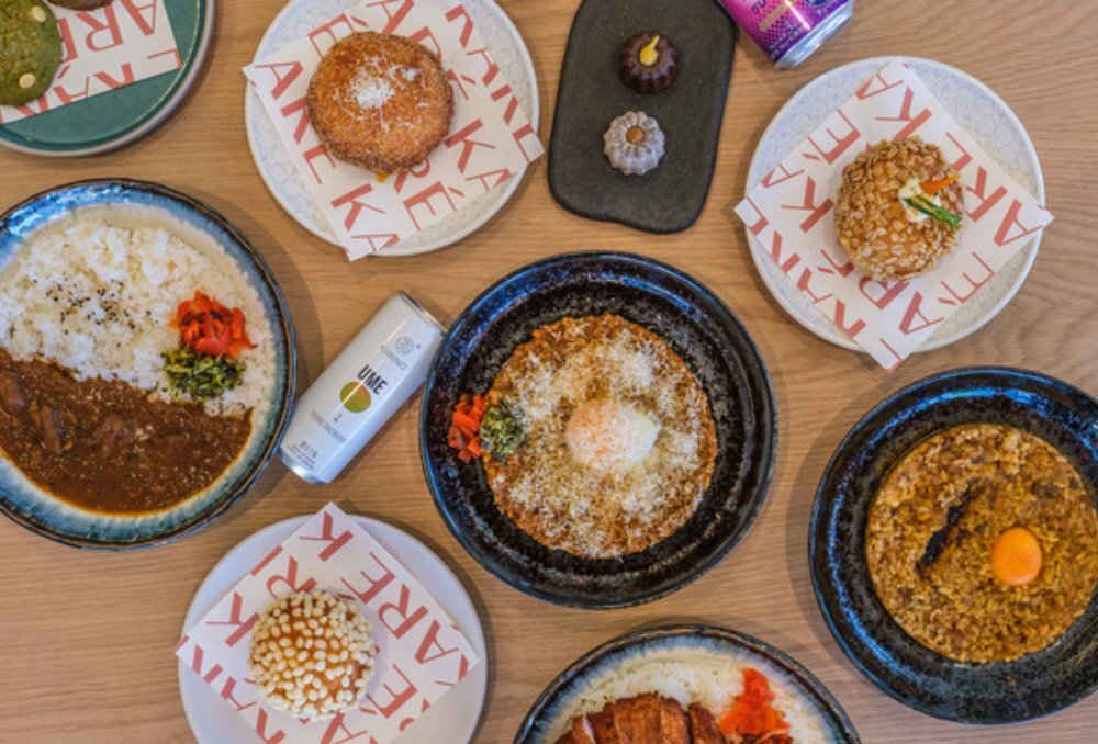 Bird's eye view shot of various plates of curry rice and sweets.