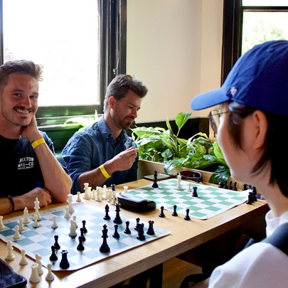 A social chess gathering where people are playing chess matches in an indoor setting of a bar.