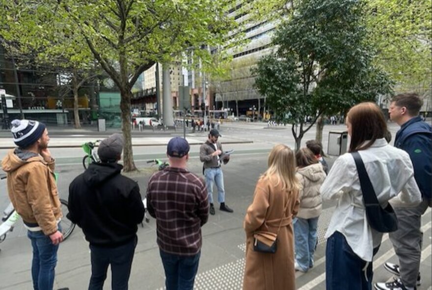 Tour group standing around a tour leader on a Melbourne street.