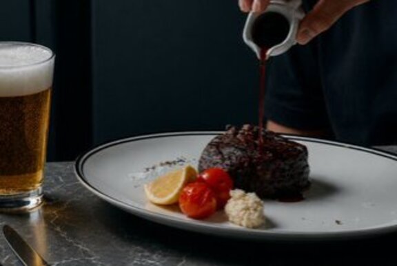 Steak on a plate with garnishes.