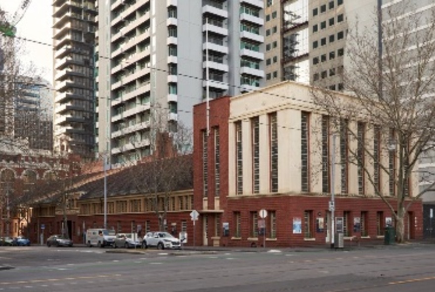 The Royal Historical Society of Victoria building on a Melbourne intersection, with city skyscrapers behind it. 