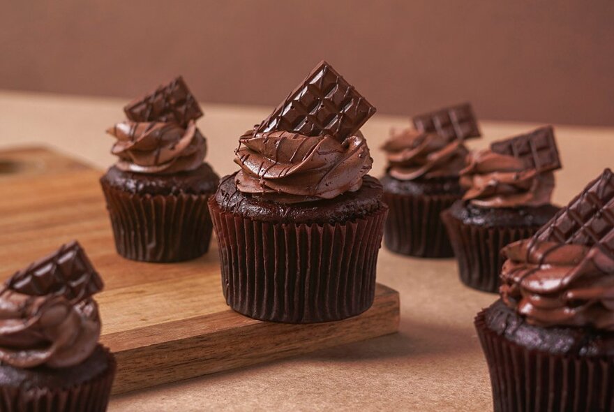 Mini chocolate cupcakes decorated with chocolate ganache icing.