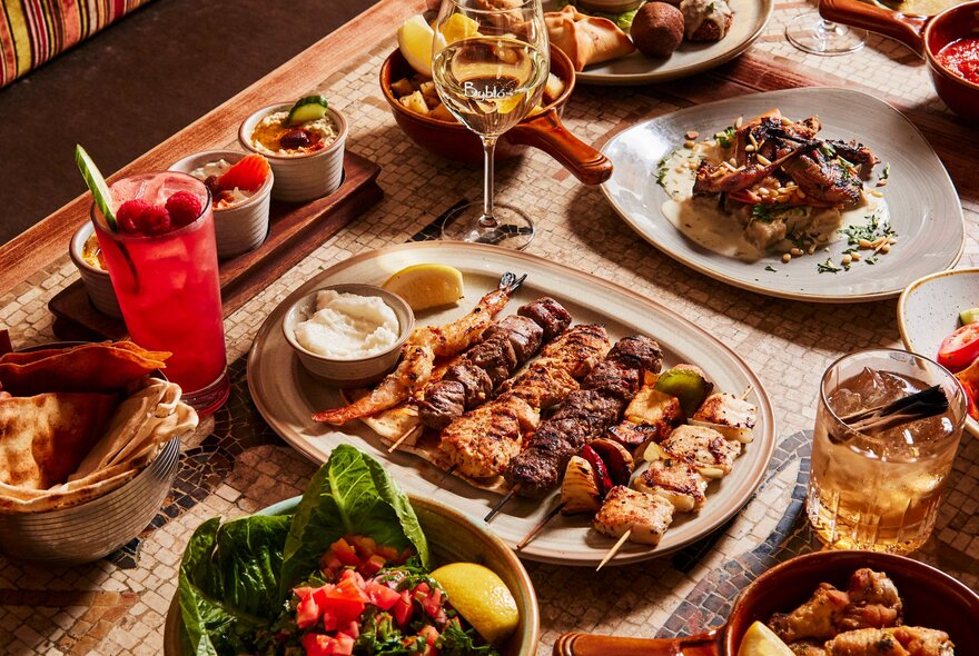 Aerial view of a table in a restaurant filled with an abundance of dishes and drinks.