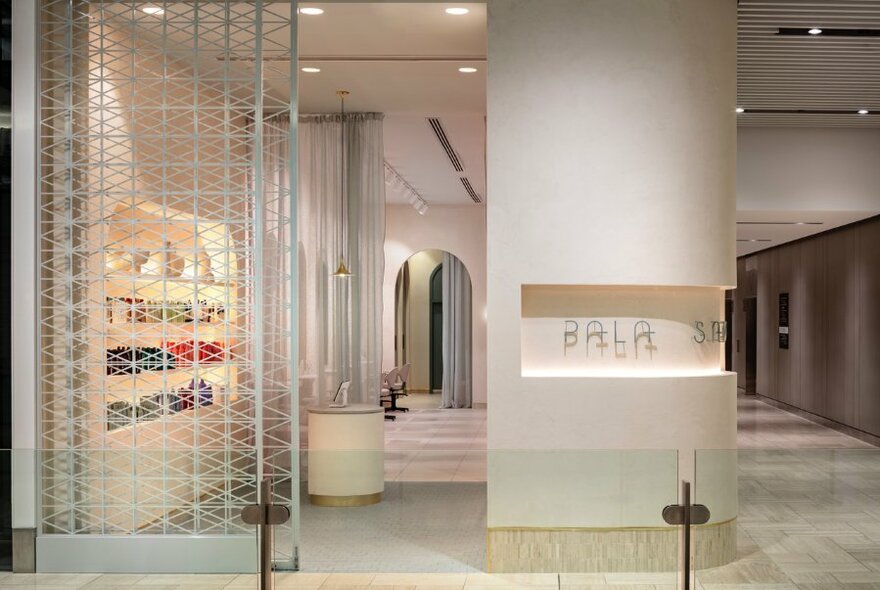 Pala Salon interior with white decor, shelving and screen.