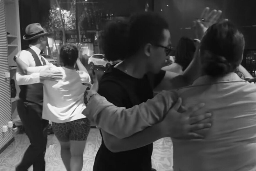 A black and white image of couples dancing salsa.