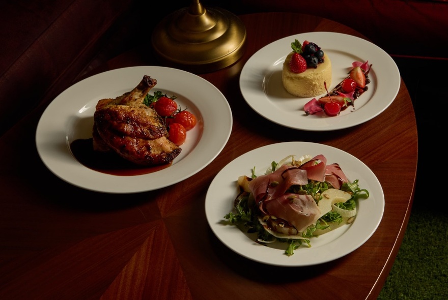 Three plates of food on a wooden table.