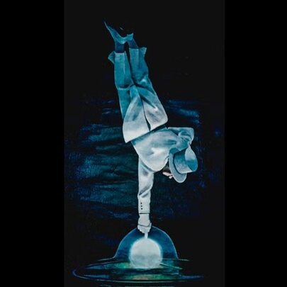 Magician balancing one finger on a globe, suspended updside down, wearing a white suit and hat.