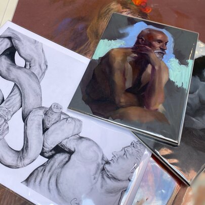 Scattered pile of artworks in different mediums and colours.