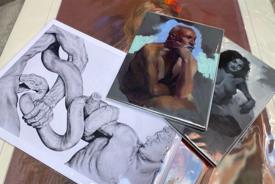 Scattered pile of artworks in different mediums and colours.