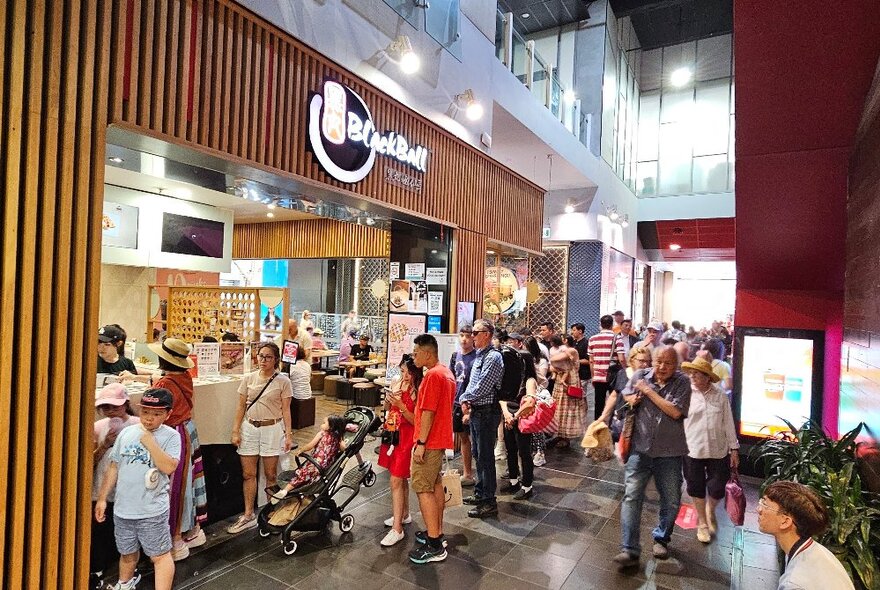 A crowd of people milling outside Blackball Chinatown.
