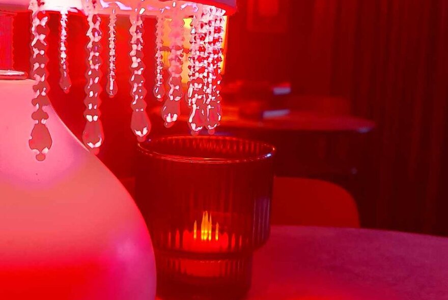 Red-lit lamp with crystal drops and red candle holder.