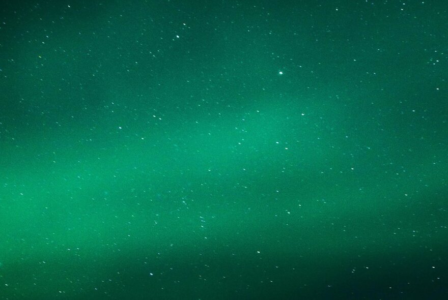 Green night sky with aurora and stars.