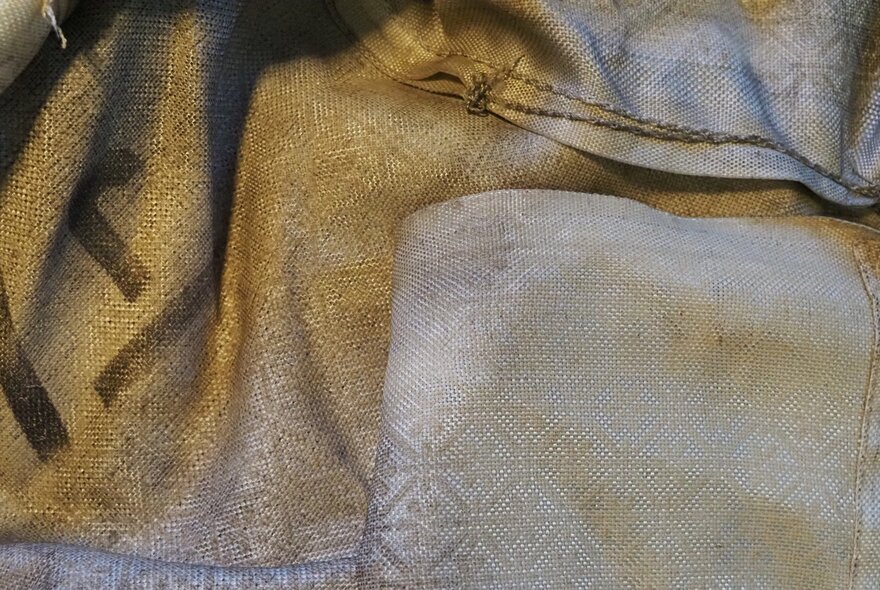Layered satin fabric in yellow and pink with embossed pattern.
