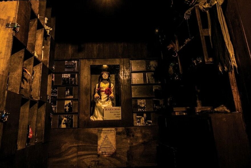 Creepy doll on display in a dark escape room.