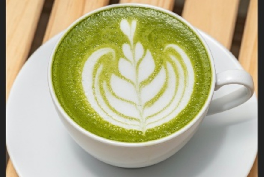 A matcha coffee with feather latte art