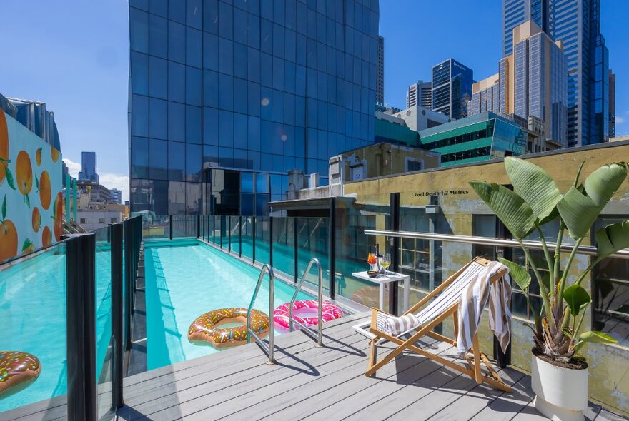 Narrow lap pool on the edge of a hotel rooftop.