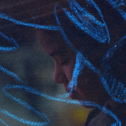 A dark image of a person's face in profile overlayed with blue pastel drawings of molars with roots. 