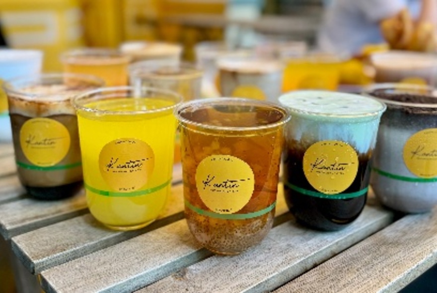 An array of different drinks in Kantin clear cups. 