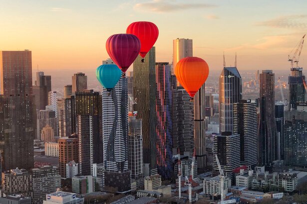 Hot air balloons flying over the city.