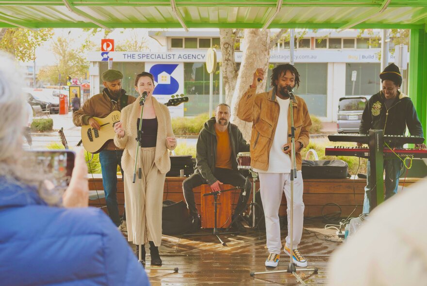 Afro-fusion artist Mikhaell performing live outdoors with his band.