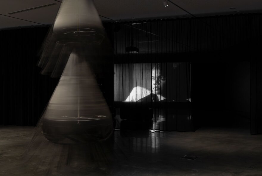 Sculptural and video installations in a dark gallery space.