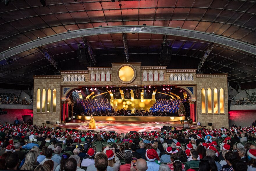 Audience seated before illuminated Sidney Myer Music Bowl stage.