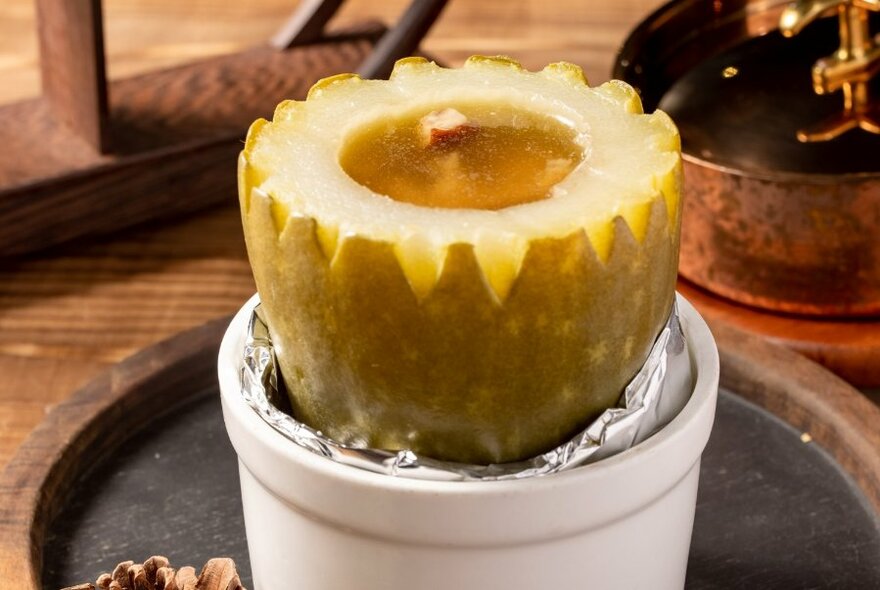 White dish with a halved melon, sitting on a tray.