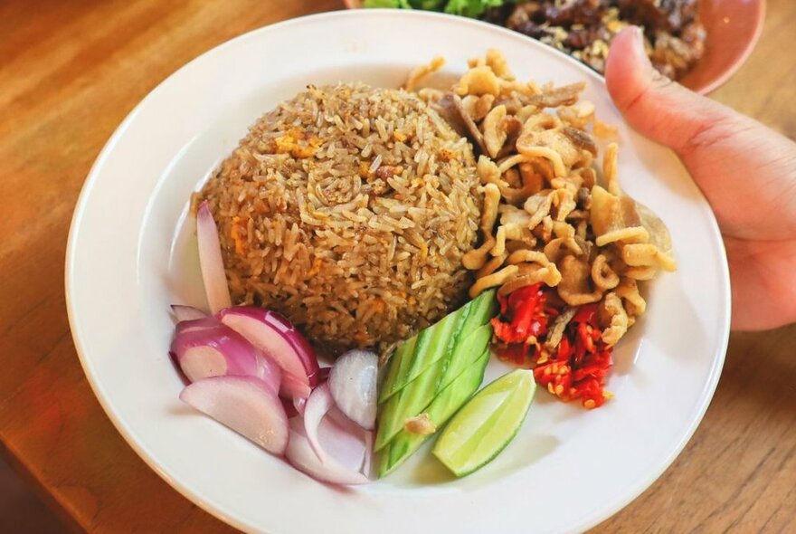 A bowl of Thai food including rice and salad.