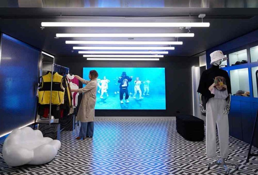 Someone browsing in a futuristic clothing store.