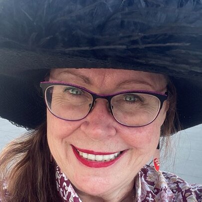 Walking tour guide Deb Robinson, a smiling middle-aged woman wearing glasses and a large black sun hat.