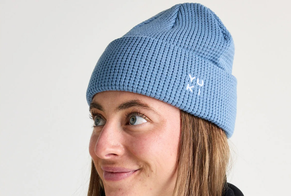A woman wearing a light blue knitted beanie.
