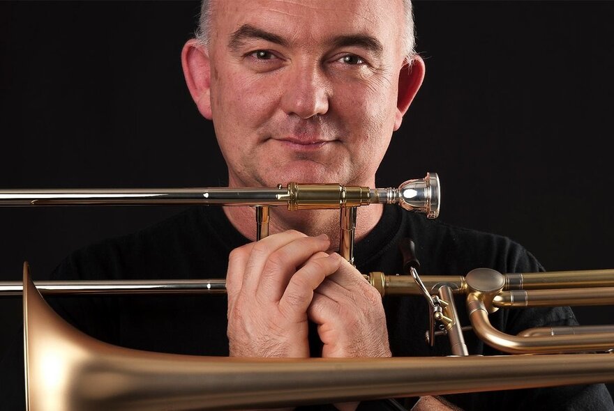 Jazz musician James Morrison smiling over his trumpet.