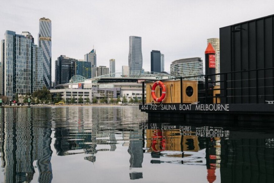 A floating black shipping container overlooking the city.