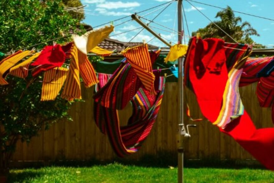 Red and gold washing blowing on a Hills Hoist clothes line. 