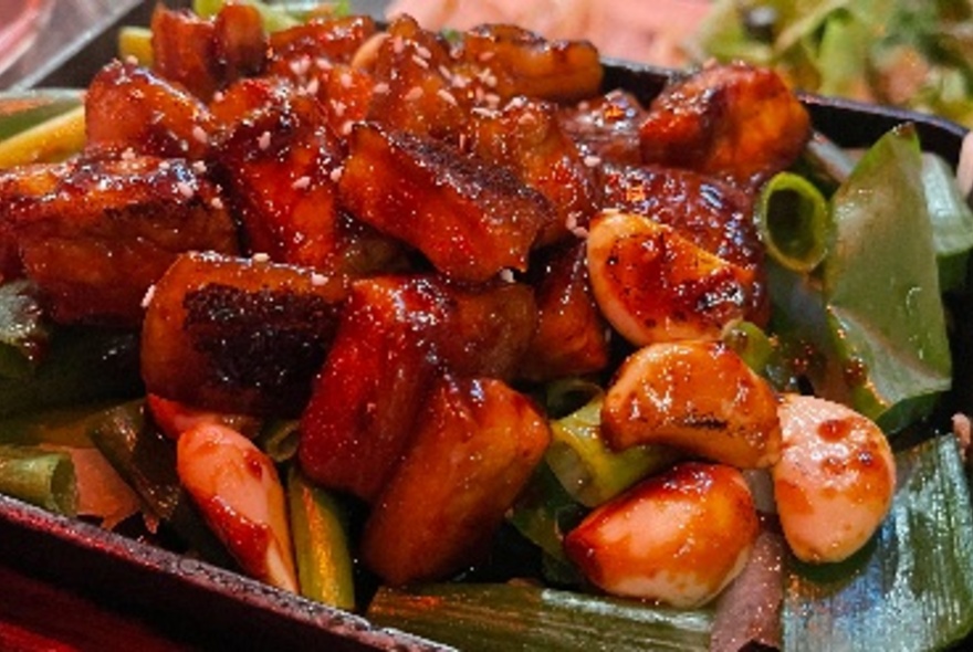 A tray loaded with a dish of red sticky Korean food.