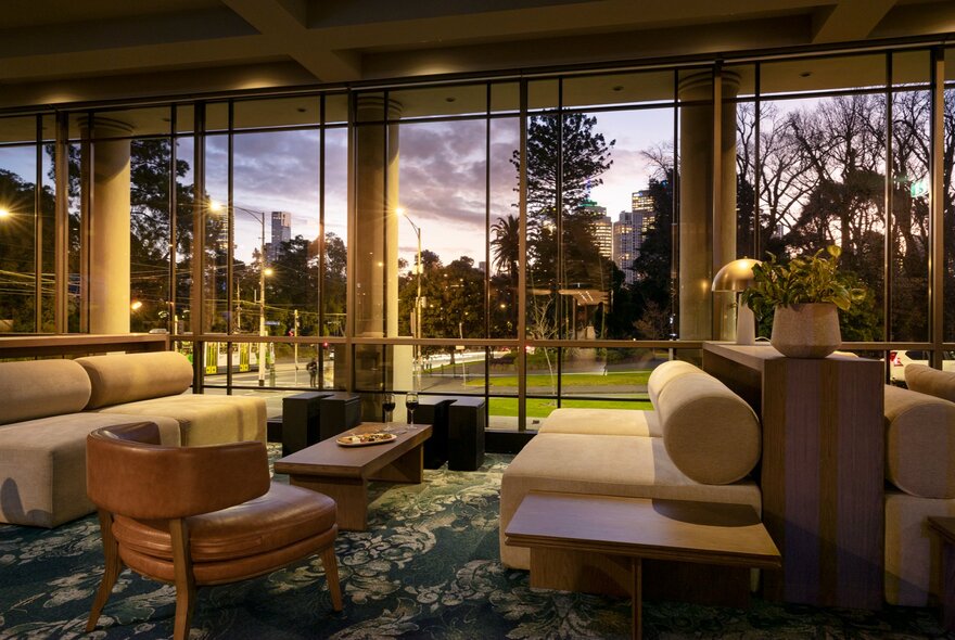 Lobby lounge of the Pullman East Melbourne featuring floor-to-ceiling windows with park views.