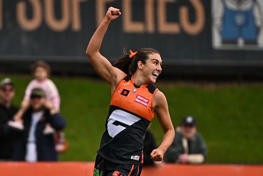 GWS Giants player raising her fist during a game.