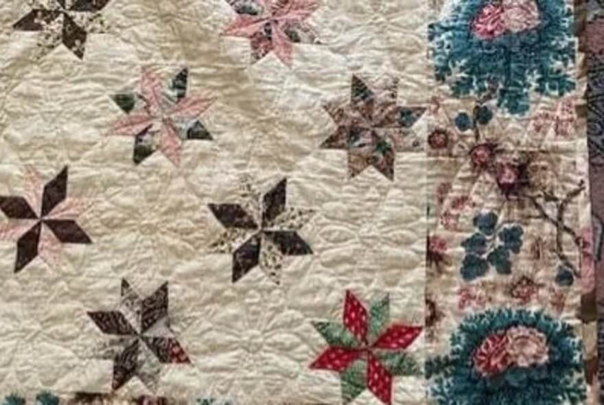 Detail of an antique quilt with decorated border with flowers.
