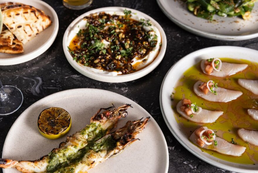 Looking down on a table with various plates of food.