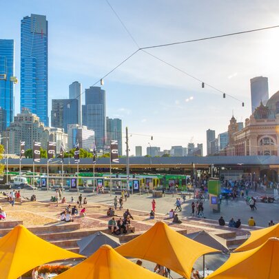 Federation square on a sunny day overlooking Flinders Station and the city skyline
